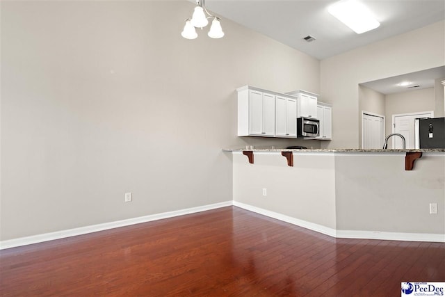 121 Parmelee Dr, Murrells Inlet, SC 29576 - kitchen with stainless steel microwave, refrigerator, a kitchen breakfast bar, dark wood finished floors, and high vaulted ceiling