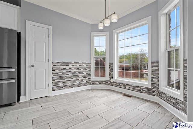 unfurnished dining area with ornamental molding
