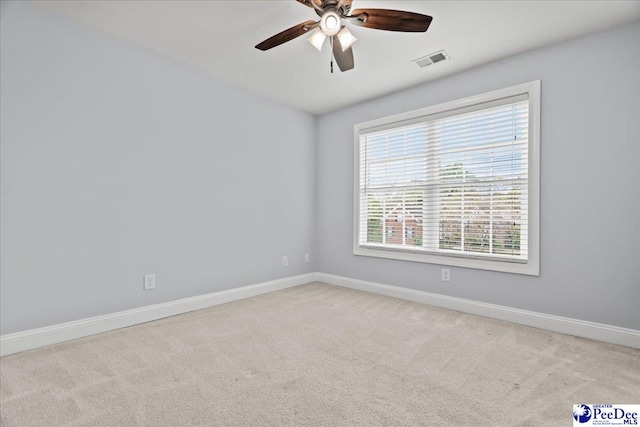 unfurnished room with visible vents, ceiling fan, carpet flooring, and baseboards