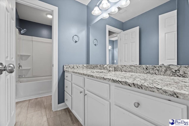 bathroom featuring baseboards, vanity, and shower / bathtub combination