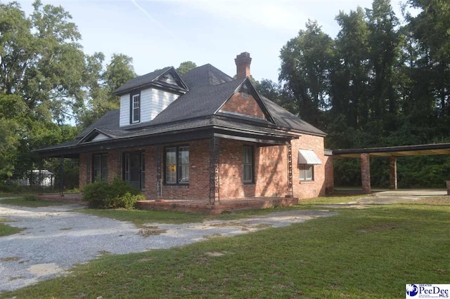 view of side of home with a lawn and a carport