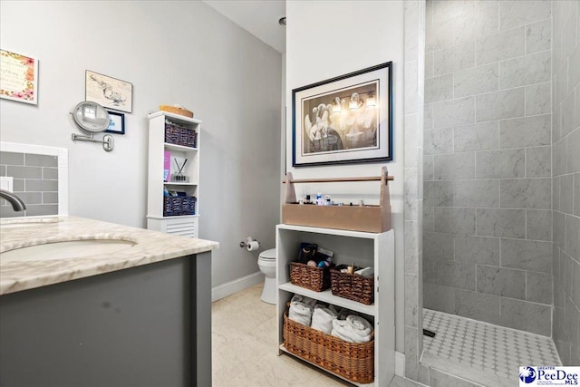 full bath featuring baseboards, vanity, toilet, and a walk in shower