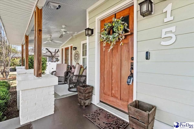 view of exterior entry featuring covered porch and ceiling fan