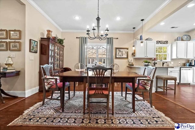 dining area with baseboards, ornamental molding, dark wood-type flooring, and a notable chandelier