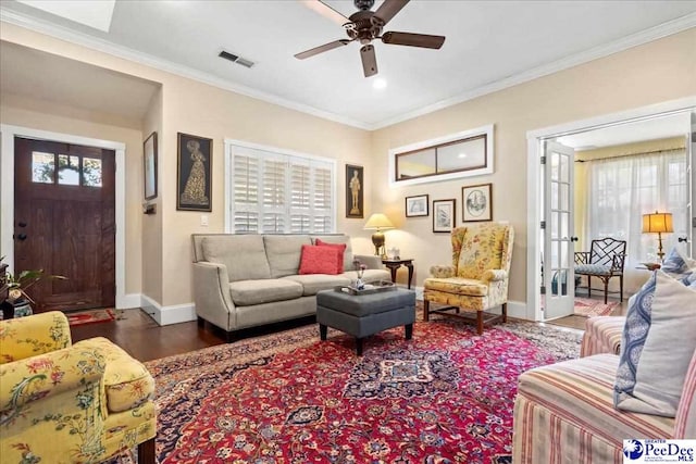 living room featuring dark wood-style floors, visible vents, ornamental molding, and baseboards