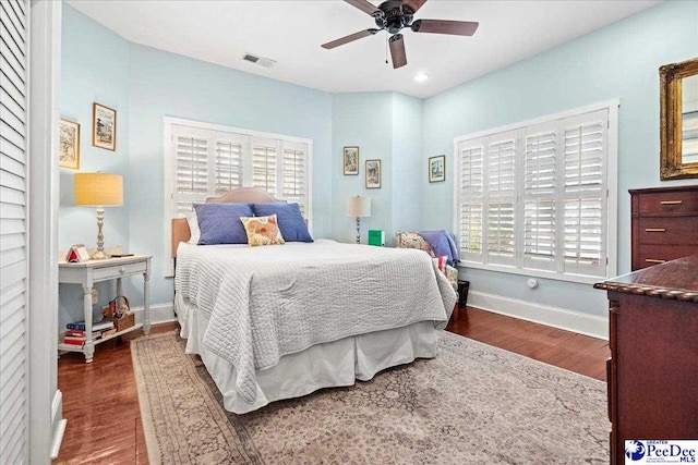 bedroom featuring dark wood-style flooring, visible vents, baseboards, and multiple windows