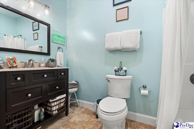 full bathroom featuring toilet, vanity, and baseboards