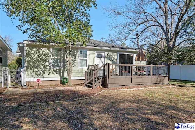 view of front of house featuring a deck and fence