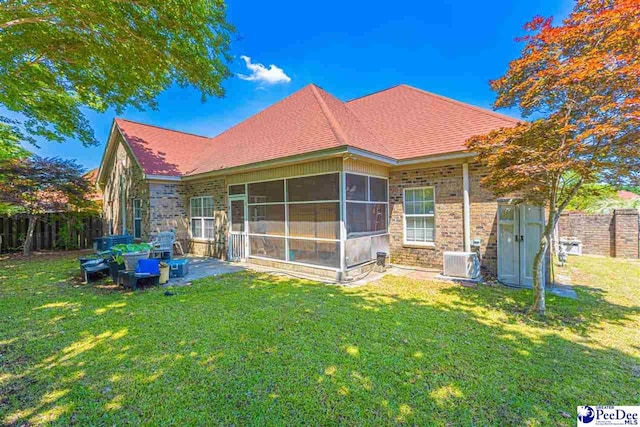 back of house featuring a yard, a sunroom, and central air condition unit