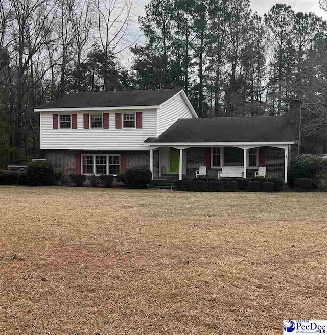 front facade featuring a front yard and covered porch