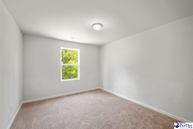 spare room featuring baseboards and carpet
