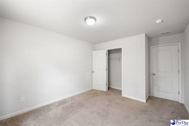 unfurnished bedroom with carpet flooring, baseboards, visible vents, and a closet