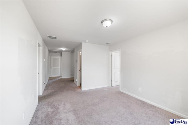 unfurnished room with light colored carpet, baseboards, and visible vents