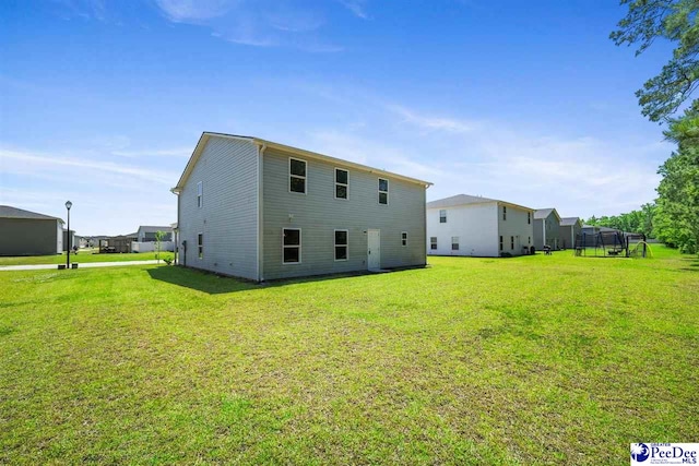 rear view of property featuring a lawn