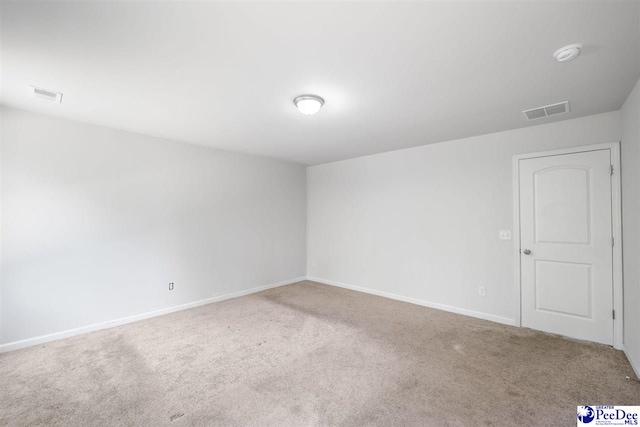 carpeted spare room with baseboards and visible vents