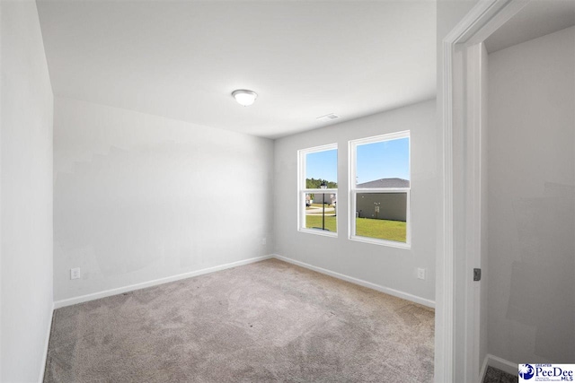 unfurnished room featuring baseboards, visible vents, and carpet