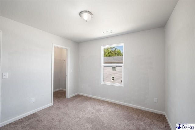 carpeted empty room with baseboards and visible vents