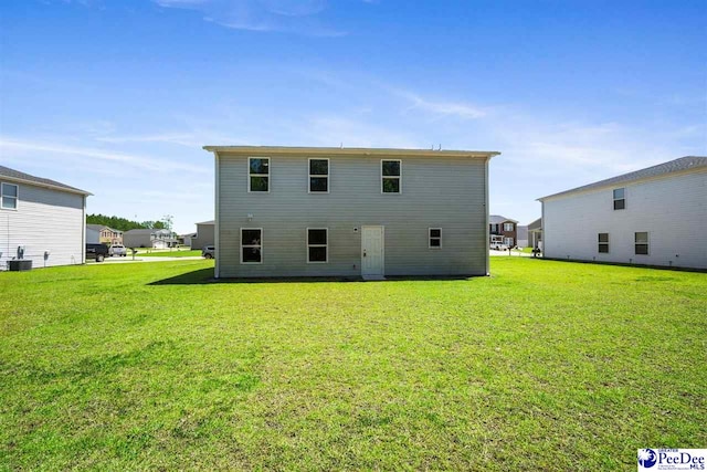 rear view of property with a lawn