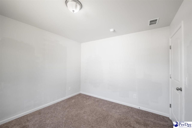 spare room with carpet floors, baseboards, and visible vents