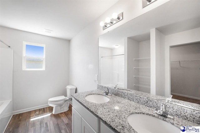full bathroom featuring toilet, baseboards, a sink, and wood finished floors