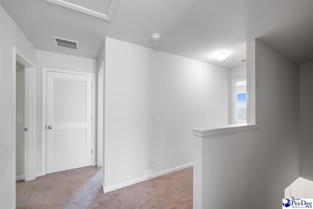 hallway featuring visible vents, carpet, baseboards, and an upstairs landing