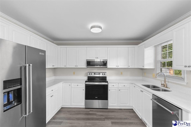 2348 Chadwick Dr, Florence, SC 29501 - kitchen with appliances with stainless steel finishes, light countertops, white cabinetry, dark wood-style flooring, and ornamental molding
