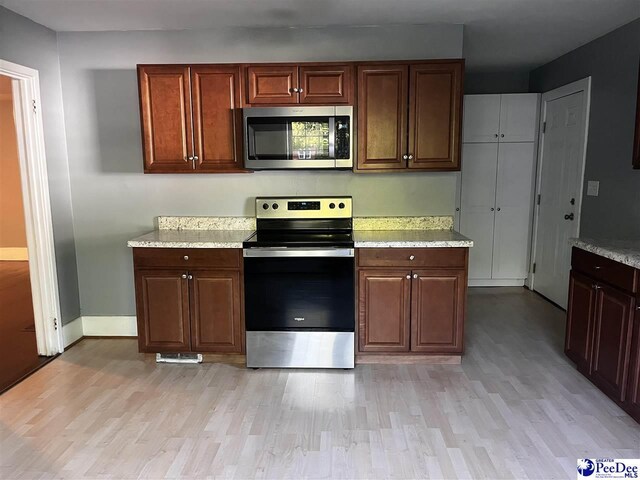 506 W College Ave, Hartsville, SC 29550 - kitchen with appliances with stainless steel finishes, light wood-type flooring, baseboards, and light stone countertops