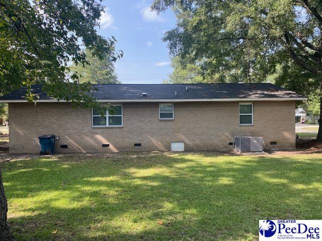 back of property featuring central AC unit and a lawn