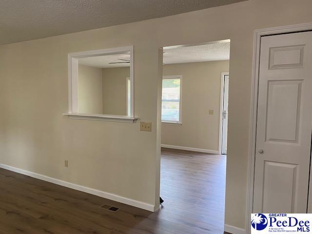 spare room featuring dark hardwood / wood-style flooring and a textured ceiling