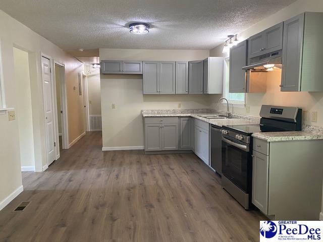 kitchen with sink, gray cabinetry, stainless steel appliances, a textured ceiling, and dark hardwood / wood-style flooring