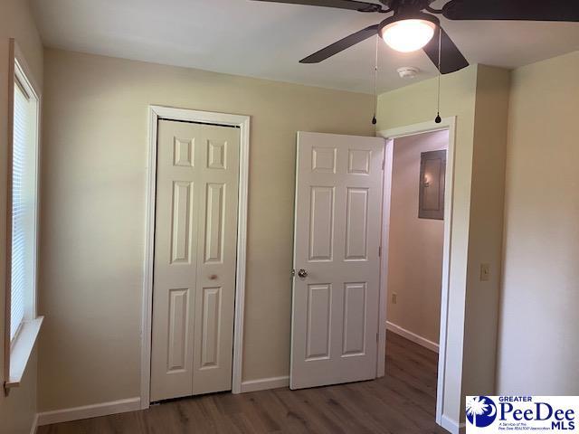 unfurnished bedroom featuring hardwood / wood-style flooring, a closet, and ceiling fan