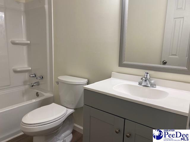 full bathroom featuring shower / tub combination, vanity, and toilet