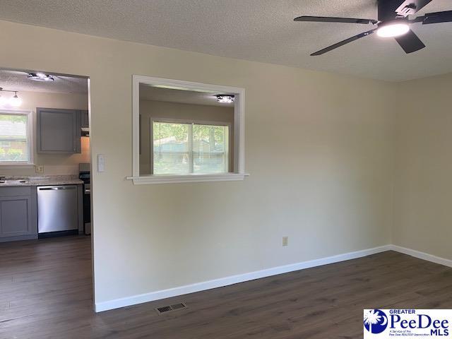 unfurnished room with plenty of natural light, dark hardwood / wood-style flooring, and a textured ceiling