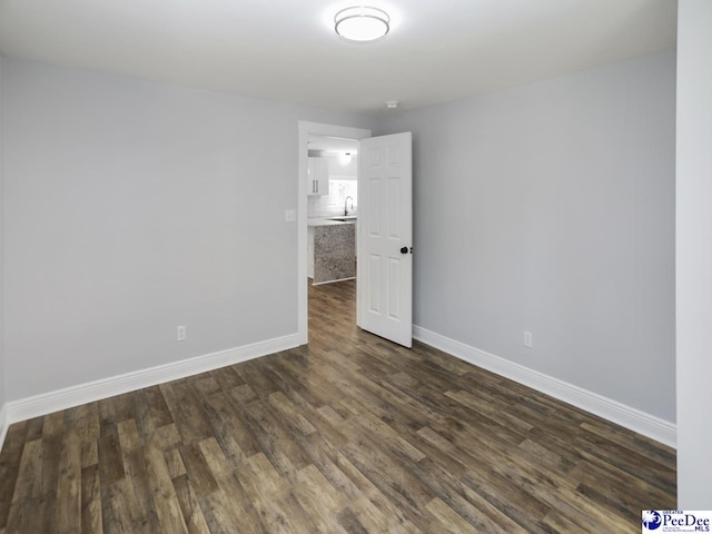 906 Gladstone St, Florence, SC 29501 - unfurnished room featuring baseboards, dark wood-style flooring, and a sink