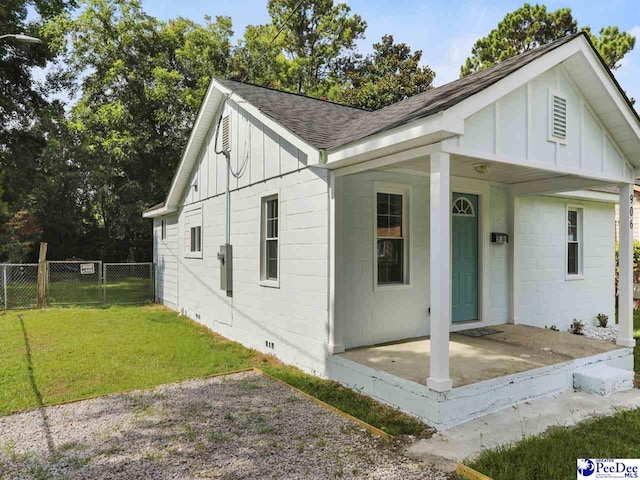 906 Gladstone St, Florence, SC 29501 - view of front facade featuring board and batten siding, roof with shingles, and a patio area