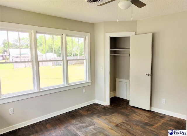 unfurnished bedroom with dark wood-type flooring, a closet, and a textured ceiling