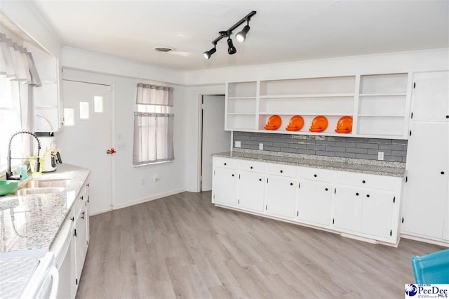 kitchen featuring light hardwood / wood-style floors, light stone countertops, sink, and white cabinets