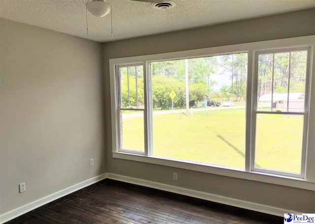 spare room with dark hardwood / wood-style floors and a textured ceiling