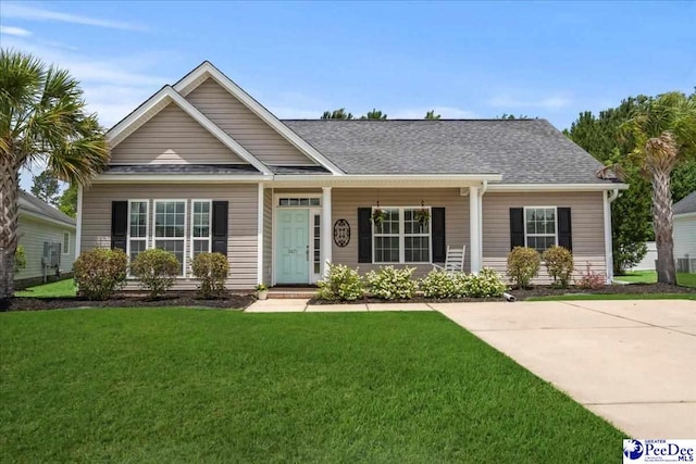 3471 Sweetgrass Dr, Florence, SC 29501 - view of front of property featuring a front lawn, a shingled roof, and a porch