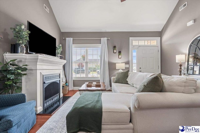 3471 Sweetgrass Dr, Florence, SC 29501 - living area with vaulted ceiling, a fireplace with flush hearth, wood finished floors, and baseboards