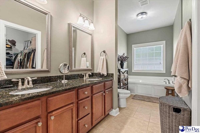 3471 Sweetgrass Dr, Florence, SC 29501 - full bathroom featuring toilet, a garden tub, double vanity, tile patterned flooring, and a spacious closet
