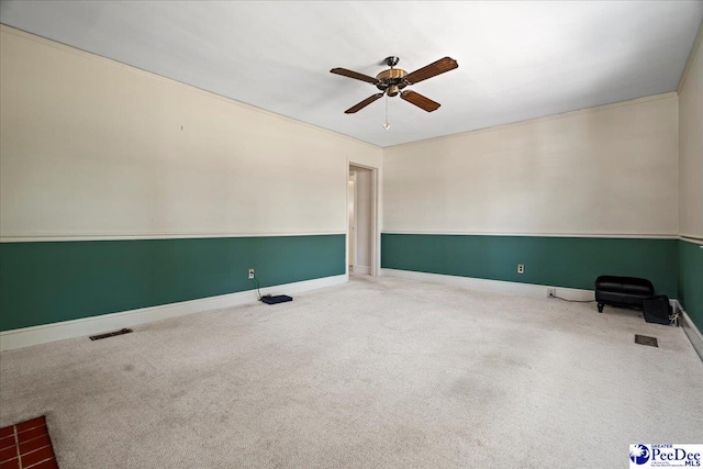 spare room featuring ceiling fan, carpet, and baseboards