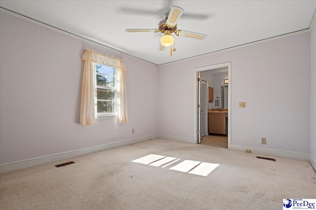 unfurnished room featuring baseboards, visible vents, a ceiling fan, and light colored carpet