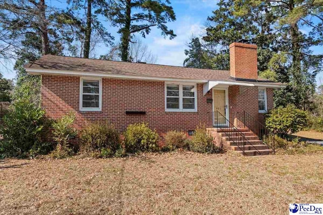 single story home with entry steps, a chimney, crawl space, a front lawn, and brick siding