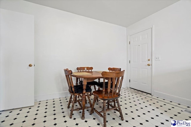 dining space featuring light floors and baseboards