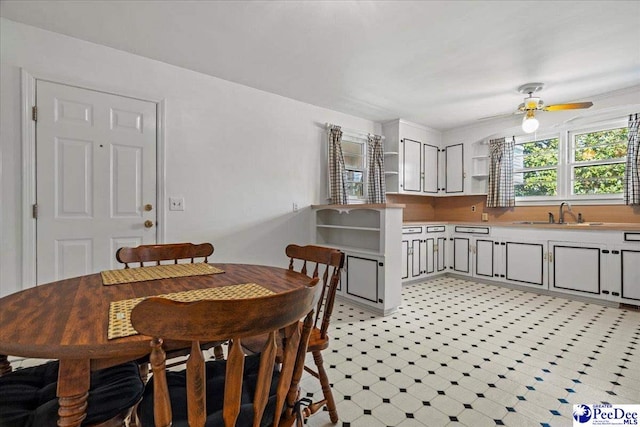 dining space with light floors and ceiling fan