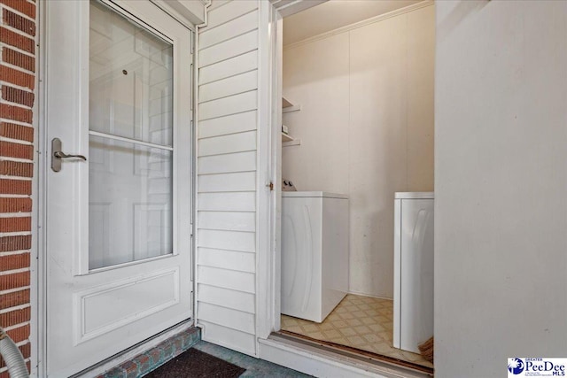 clothes washing area featuring laundry area, washer and clothes dryer, and tile patterned floors