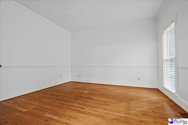 empty room with ornamental molding and hardwood / wood-style floors