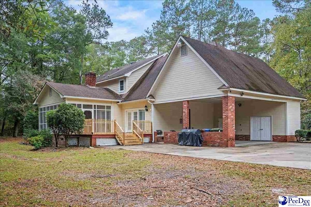 back of house with a patio, a sunroom, and a lawn