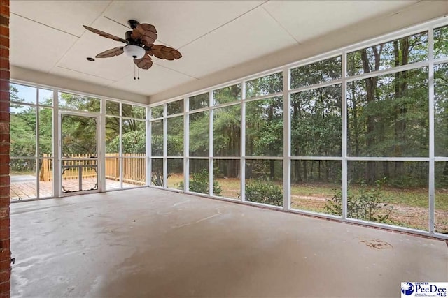 unfurnished sunroom with ceiling fan